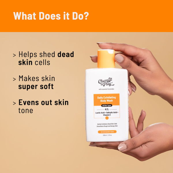A hand holding a bottle of "Chemist At Play Daily Exfoliating Body Wash". The image highlights the benefits of the product: helps shed dead skin cells, makes skin super soft, and evens out skin tone. The product is positioned against an orange background with text explaining its benefits.